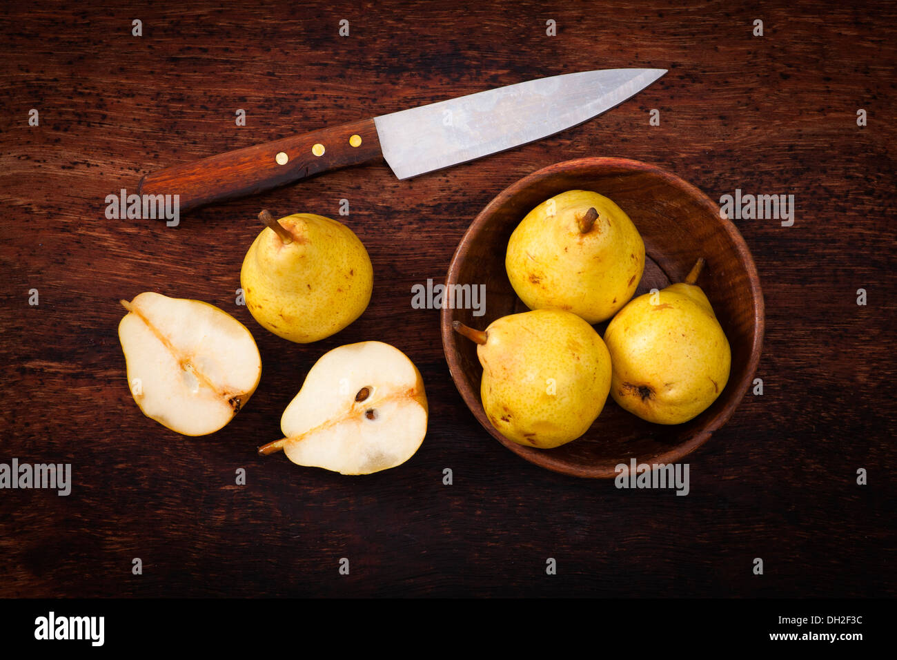 yellow pears in wooden bowl on wooden table Stock Photo