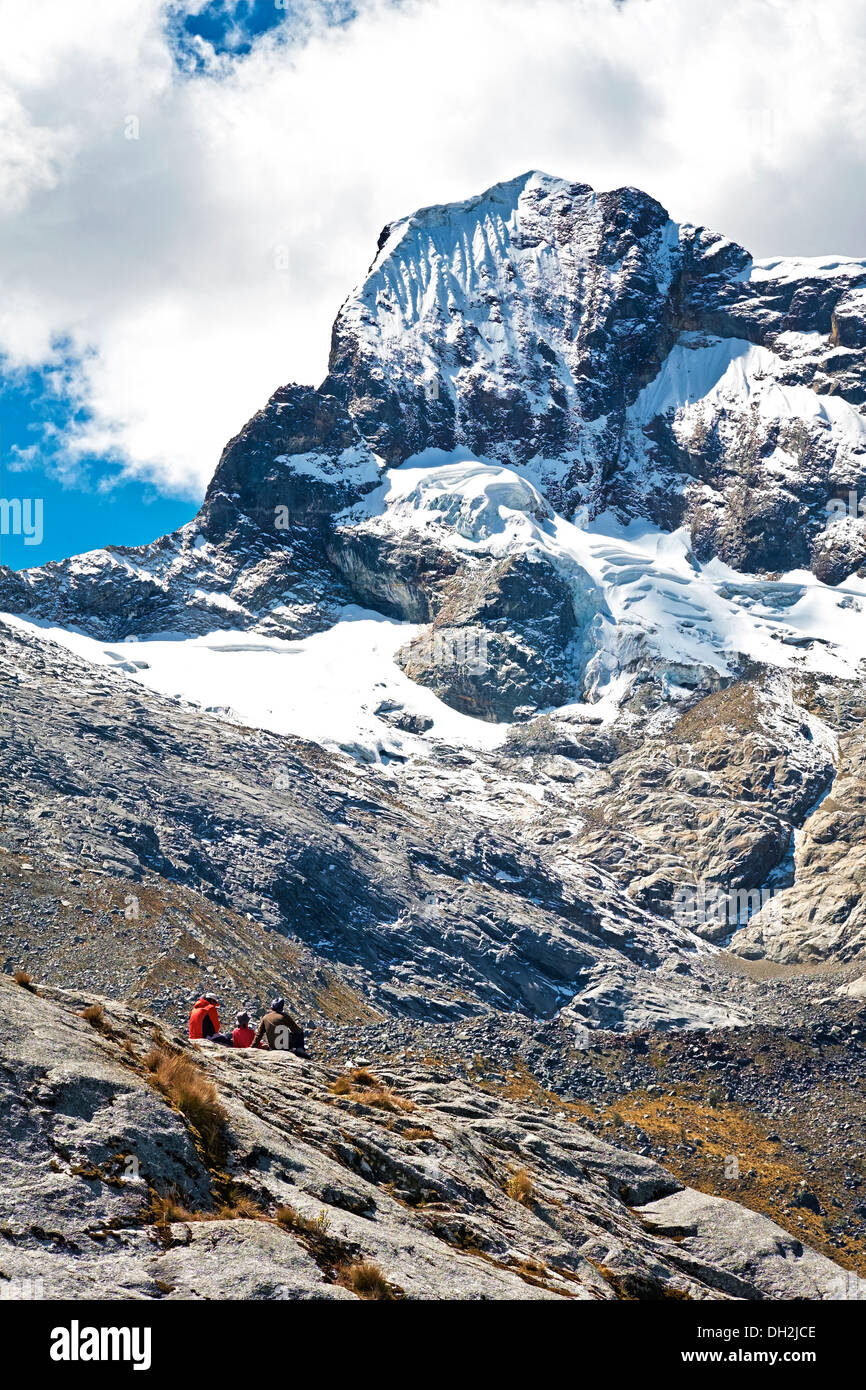 Hikers sitting below the Nev Churup Summit, Huascaran National Park in the Andes. Stock Photo