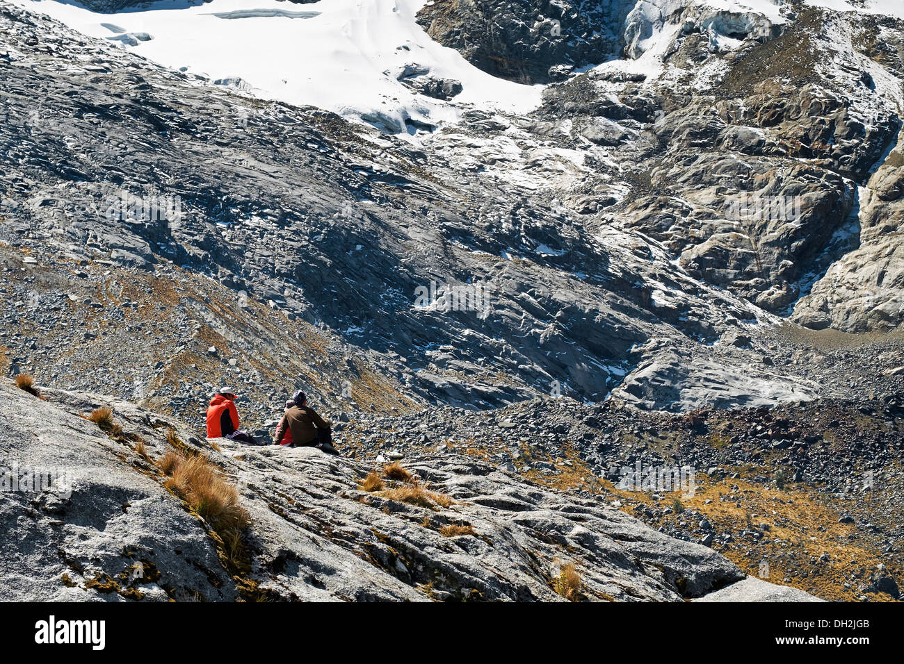 Hikers sitting below the Nev Churup Summit, Huascaran National Park in the Andes. Stock Photo