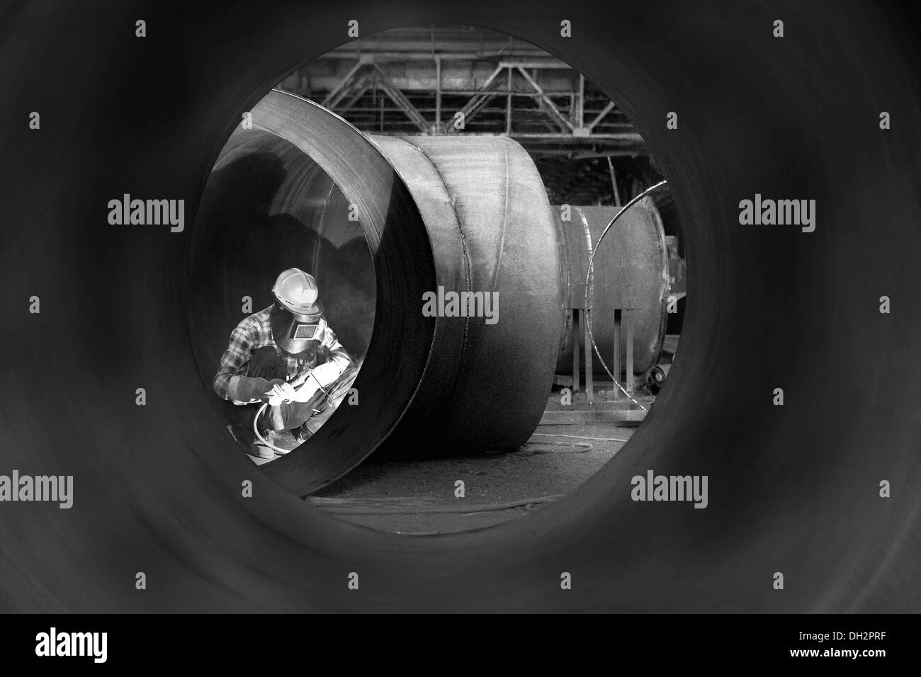 Factory worker man welding pipe with safety mask Stock Photo
