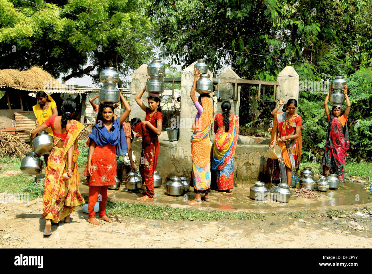 Women balancing drinking water pots on head at village well Bharuch