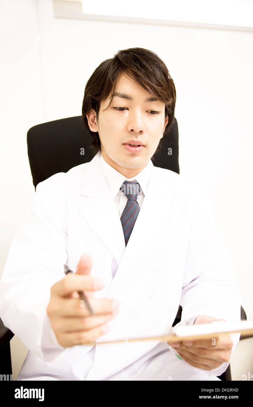 Young male doctor filling in a medical interview sheet Stock Photo
