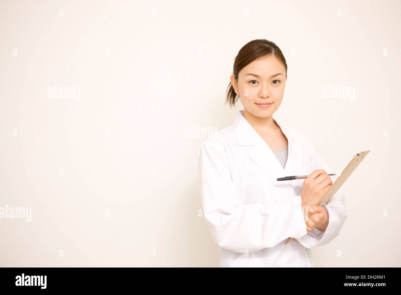 White background, young female doctor filling in a binder Stock Photo