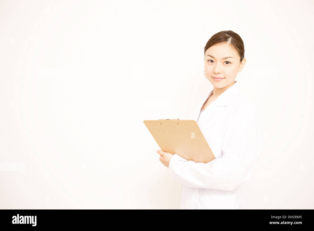 White background, young female doctor filling in a binder Stock Photo