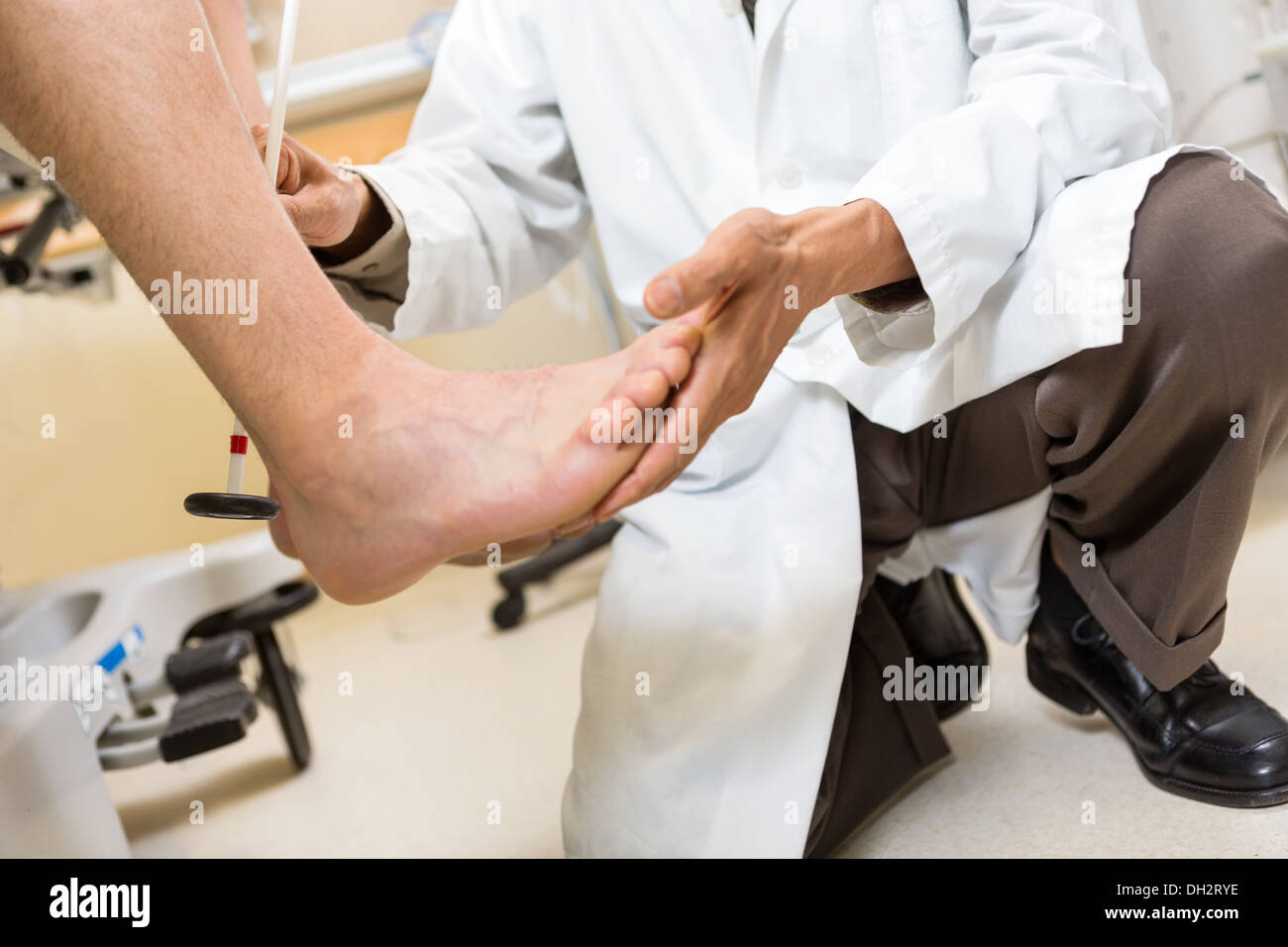 Doctor Examining Patient's Foot In Hospital Stock Photo