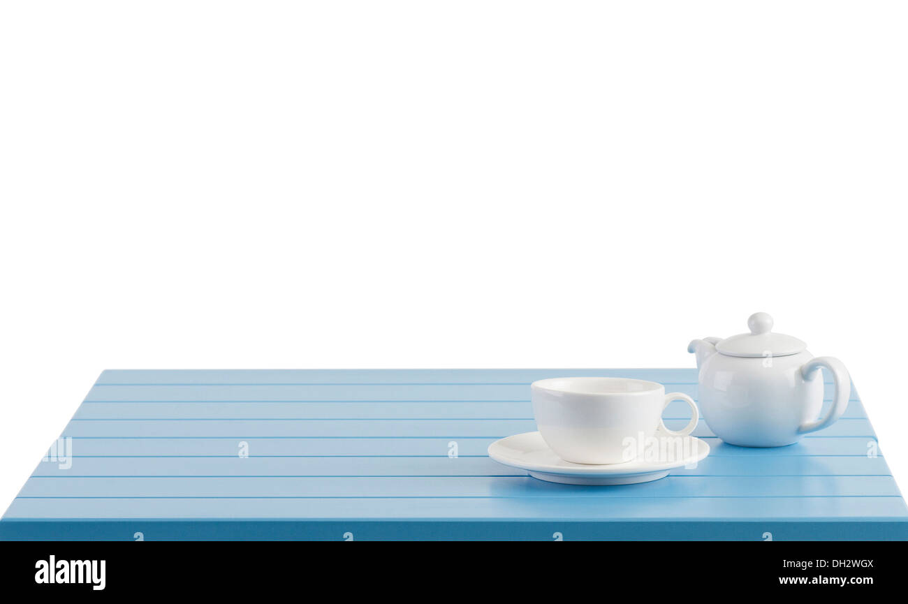 A porcelain cup and teapot on the wooden table with empty space Stock Photo
