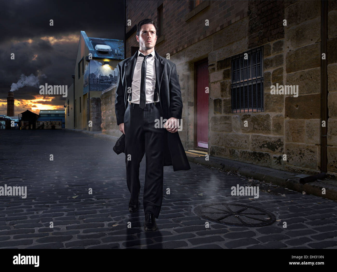 Mysterious male walking down old street at night Stock Photo