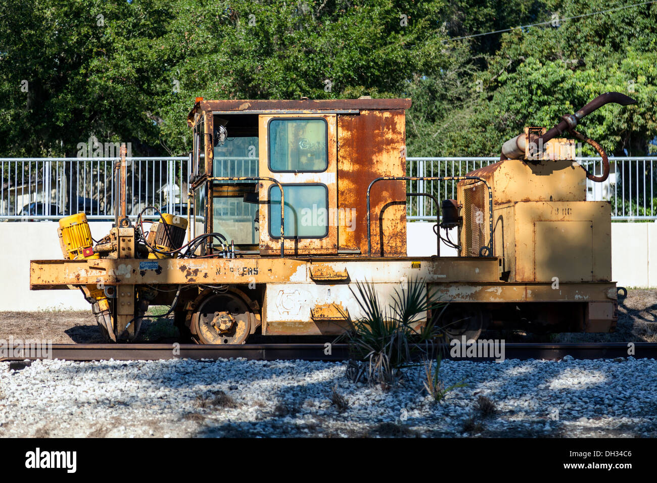 Old rusting track-mounted railroad utility repair vehicle sitting on a side track spur line in Mount Dora in Florida. Stock Photo