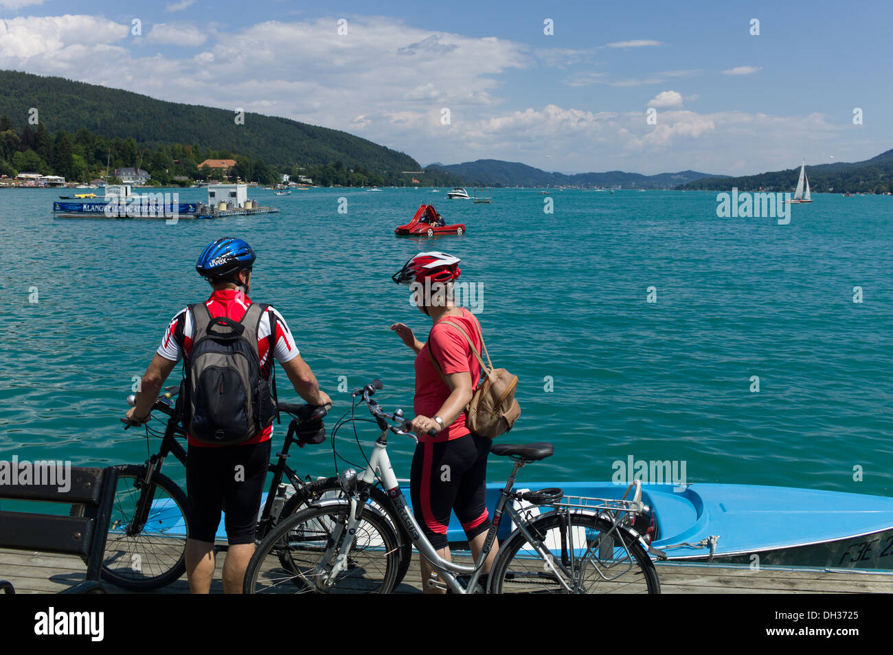 Mountain Bikers take in the view of the Lake of the popular holiday resort of Velden am Worthersee in Austria Stock Photo