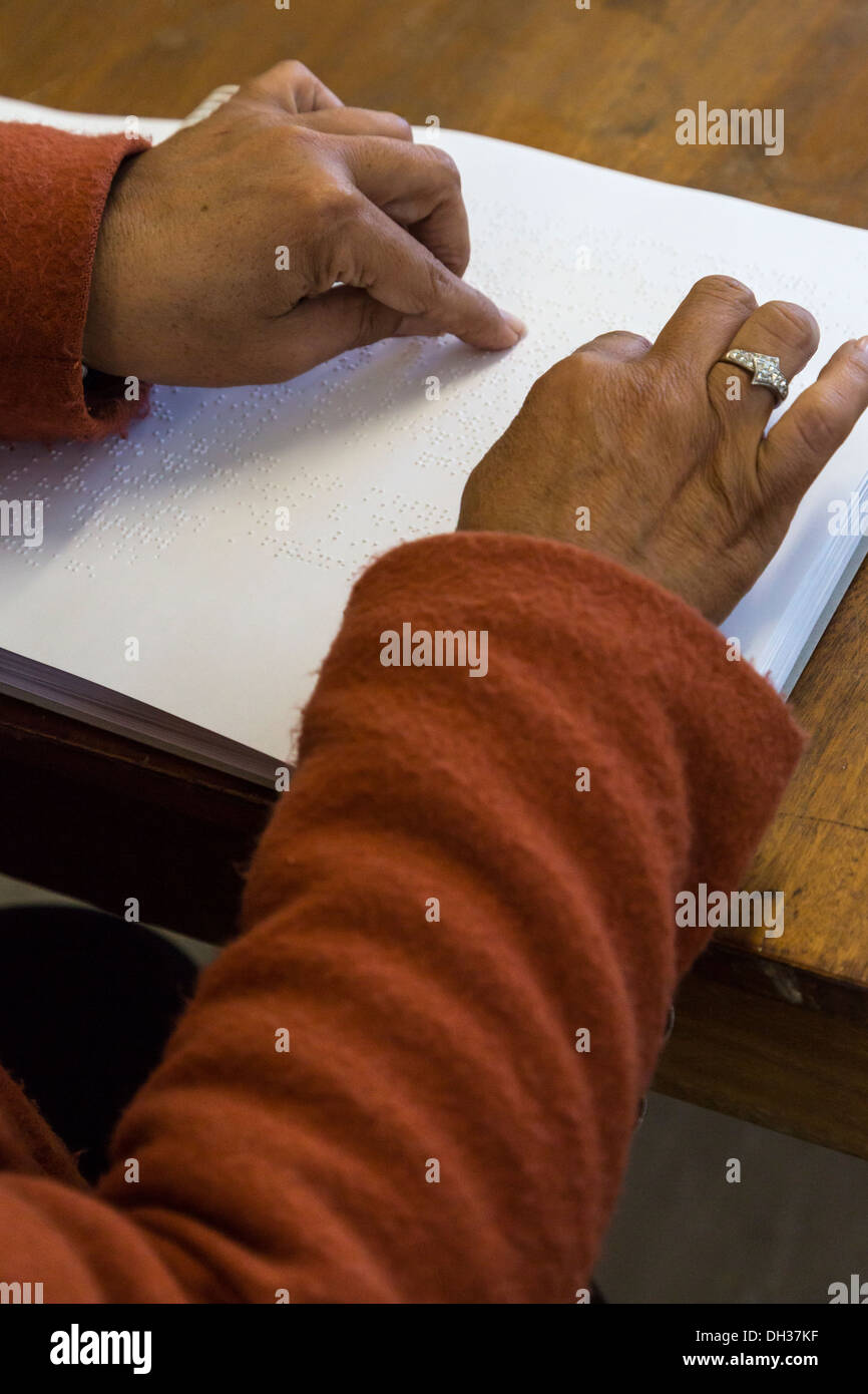 South Africa, Cape Town. Editor Using the Fingertips to Read a Braille Student Workbook. Athlone School for the Blind. Stock Photo