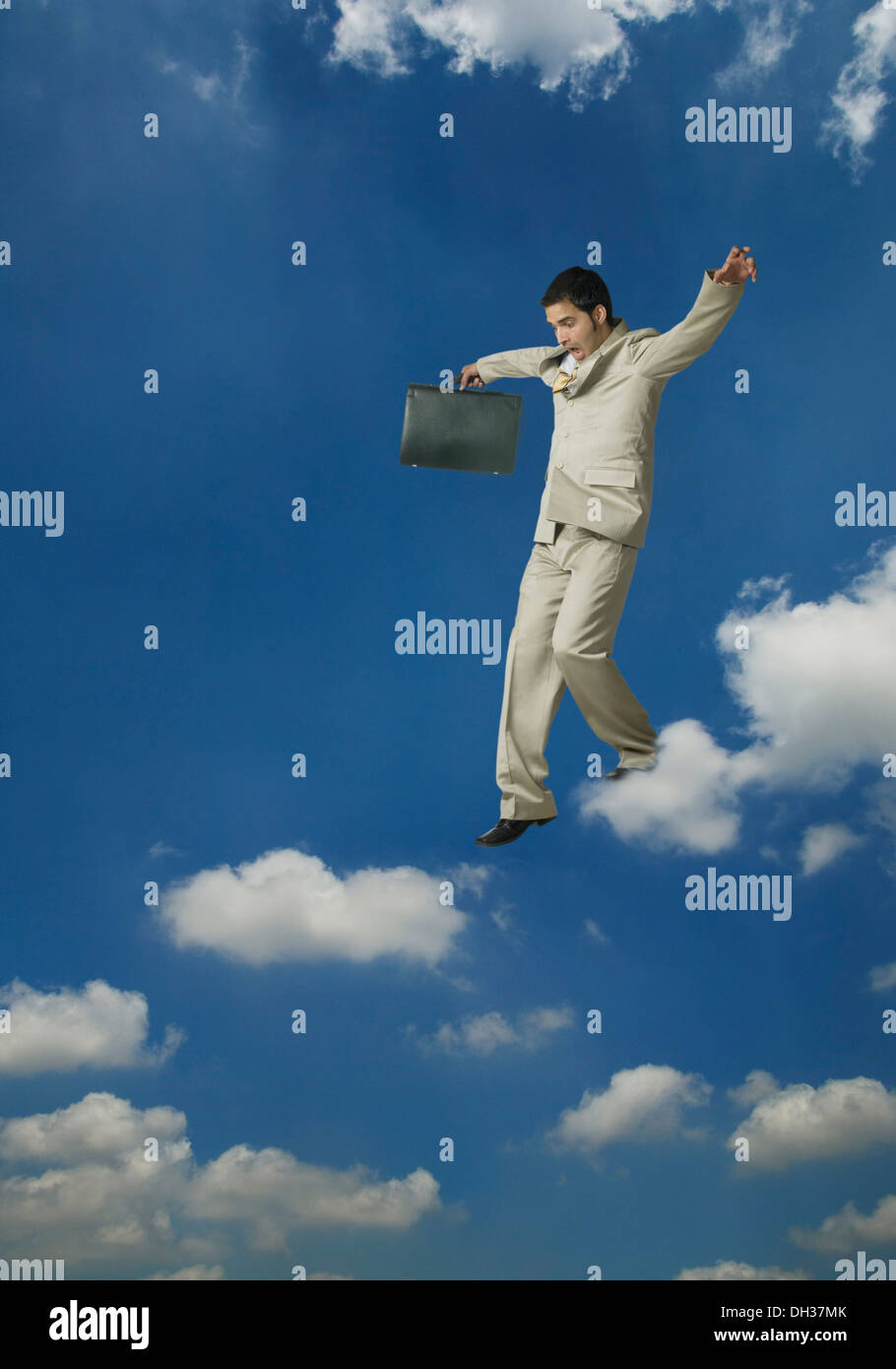 Businessman holding a briefcase and moving on clouds Stock Photo