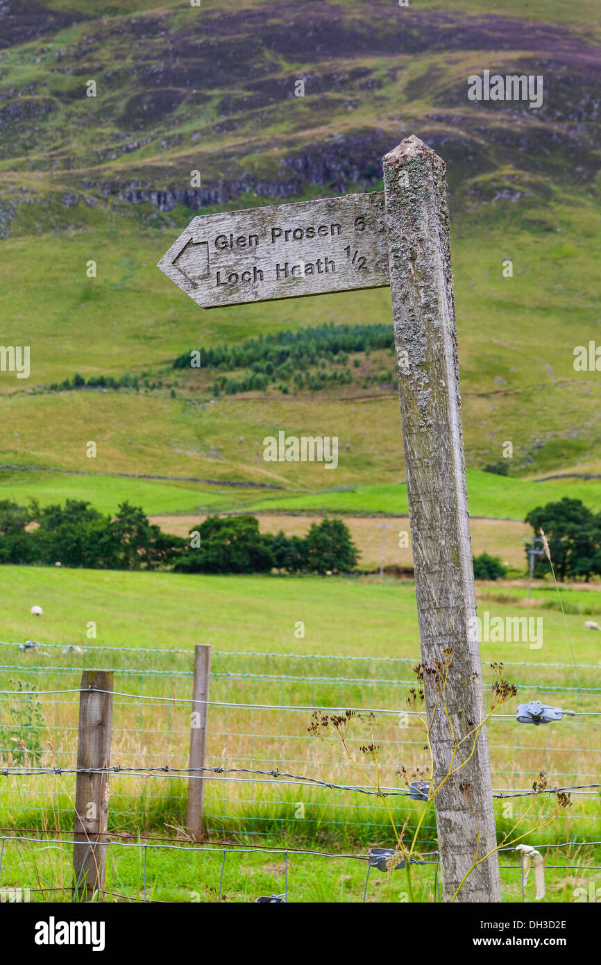 A lichen covered signpost points the way to Glen Prossen and Loch Heath at Miilton of Clova, Scotland. Stock Photo