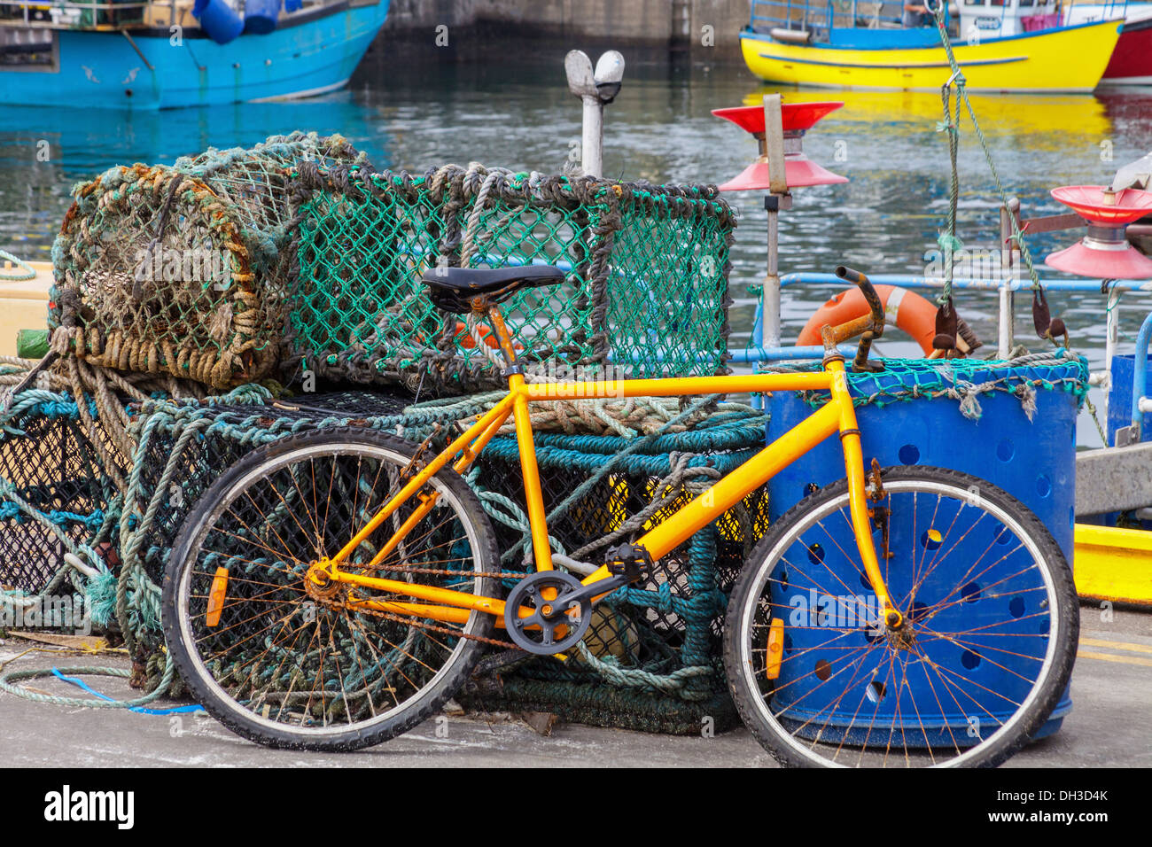 A rusty bicycle is parked by the lobster traps at Fraserburgh Harbour, Fraserburgh, Aberdeenshire, Scotland. Stock Photo