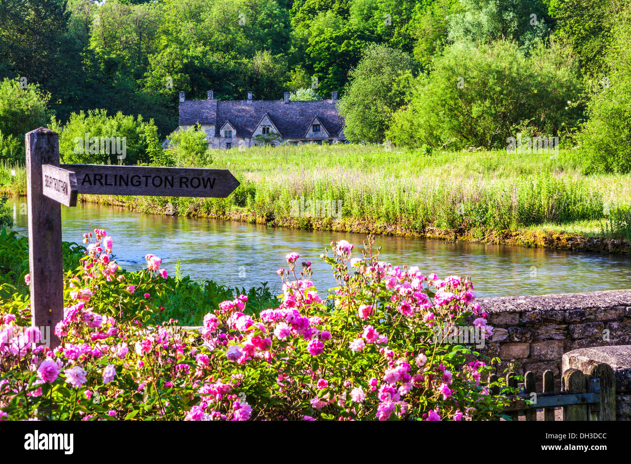 Row of weavers' cottages, Arlington Row, in Bibury, Gloucestershire viewed across the River Coln and the Rack Isle water meadow. Stock Photo
