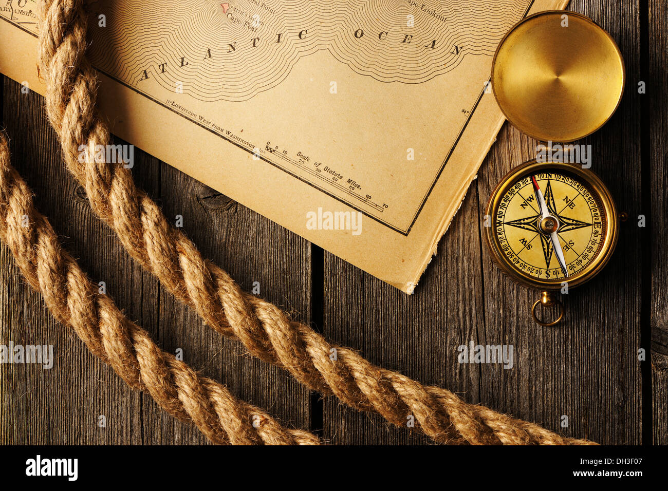 Antique compass and rope over old map Stock Photo - Alamy