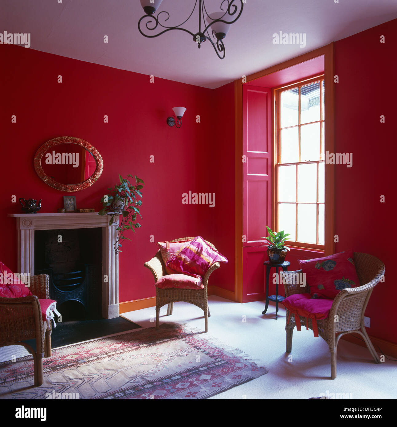 Wicker chairs with pink cushions in bright pink living room with