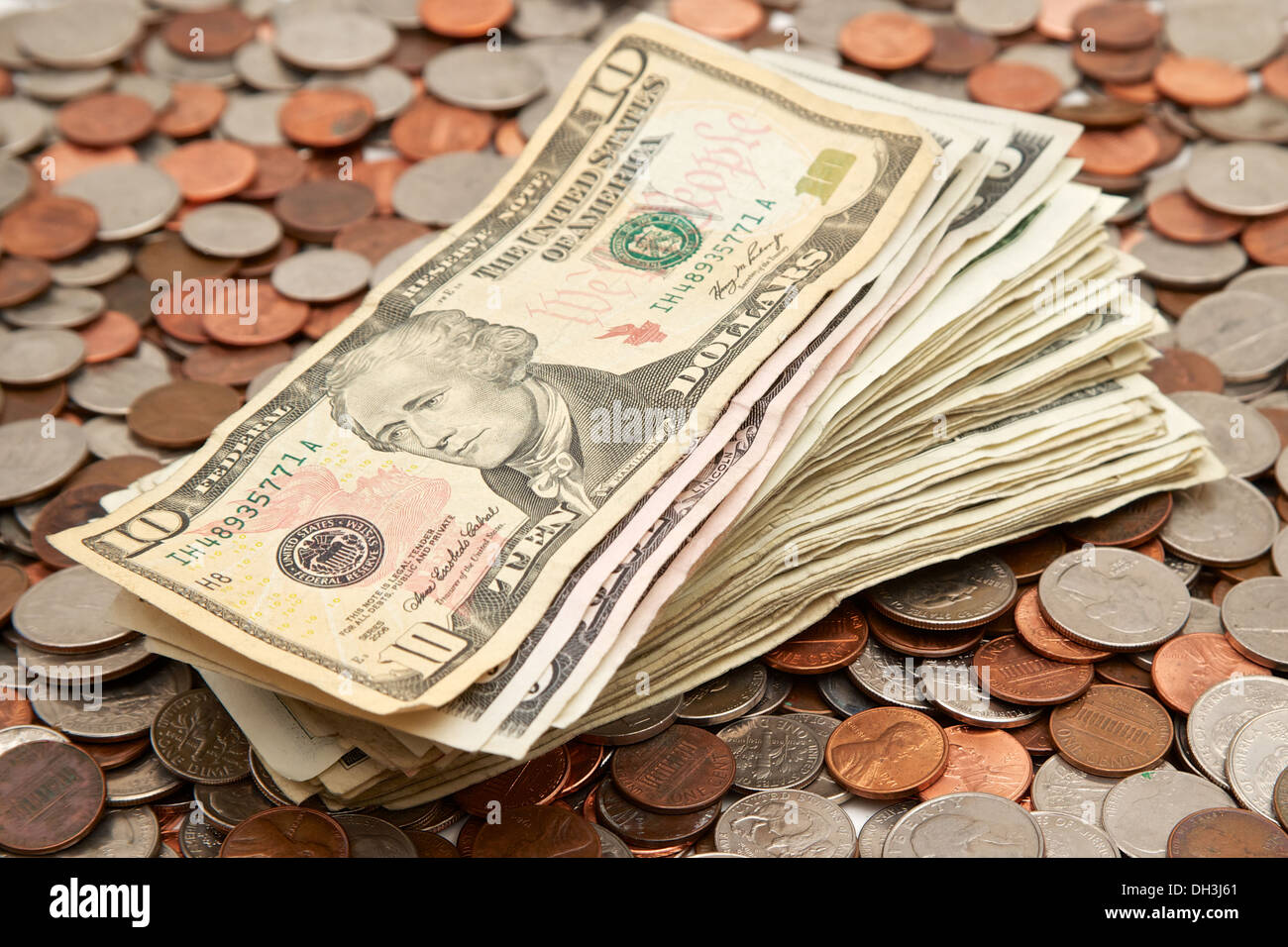 Stack of money laying on top of a pile of loose coins Stock Photo Alamy
