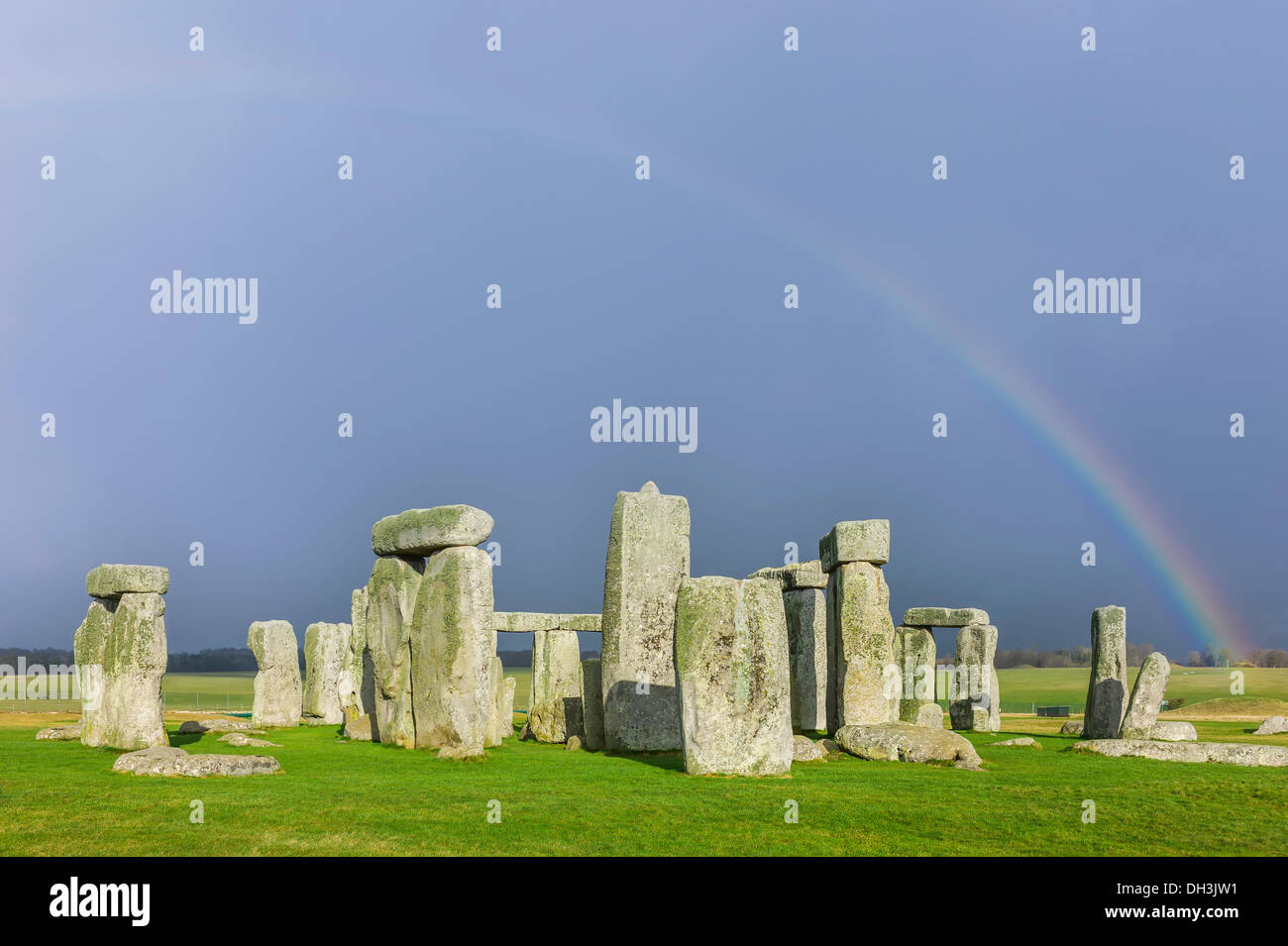 Stonehenge, prehistoric monument, on a cold winter's day with blanket cloud cover but with a hopeful rainbow as backdrop. Stock Photo