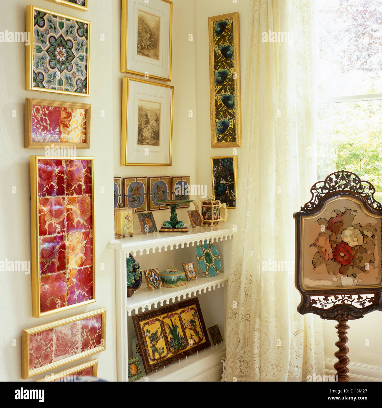 Antique tapestry screen on stand beside shelves beside colorful Stock