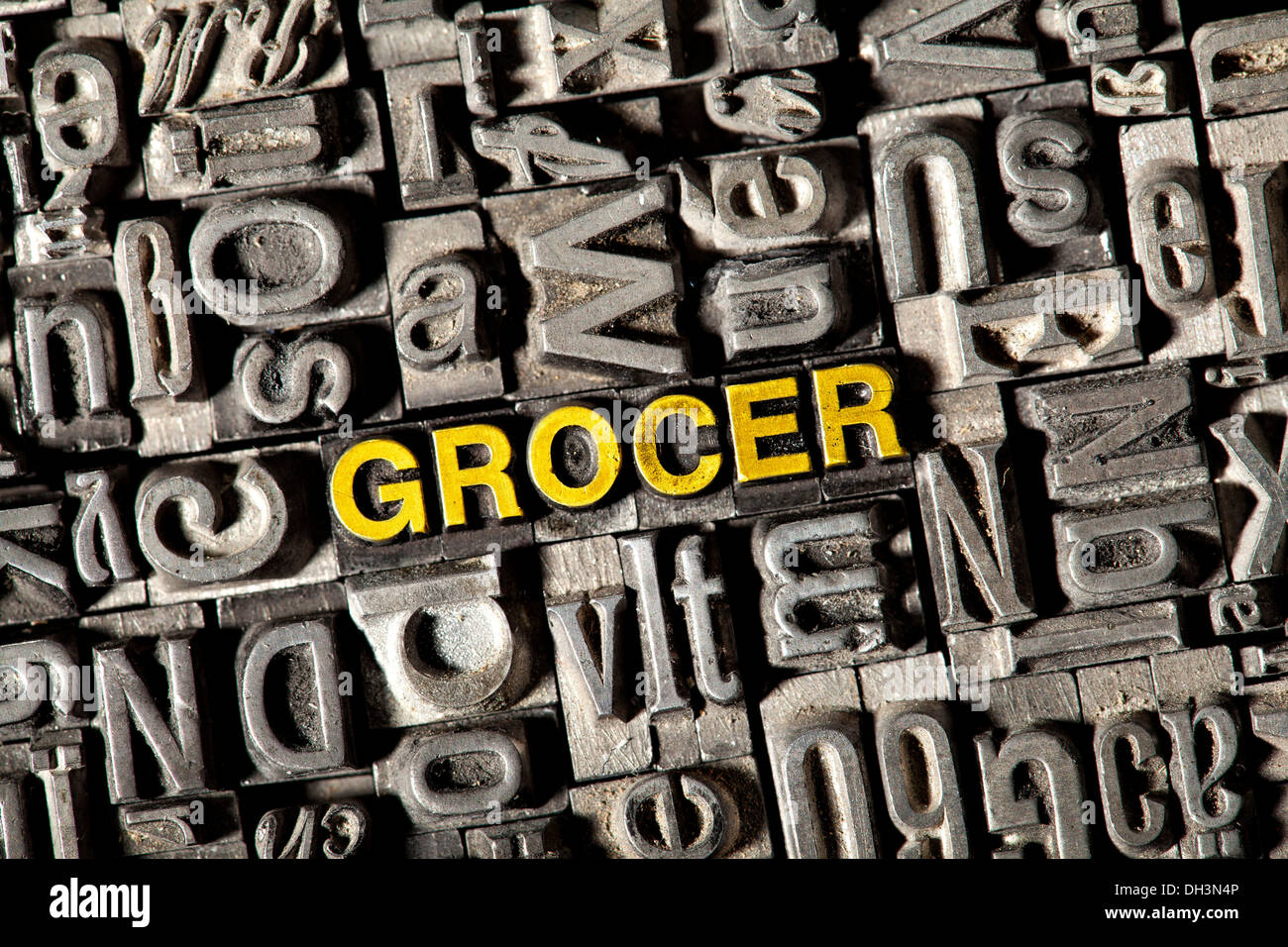Old lead letters forming the word 'GROCER' Stock Photo