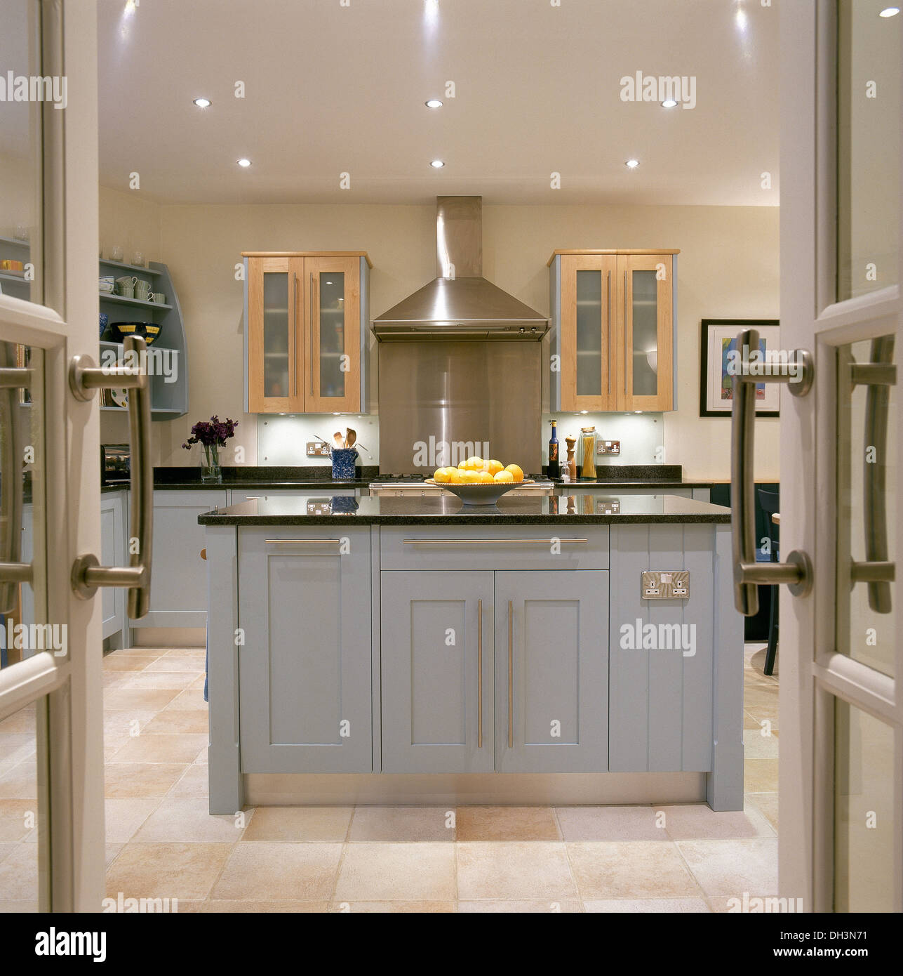 Doors open to modern kitchen with granite topped pale blue ...