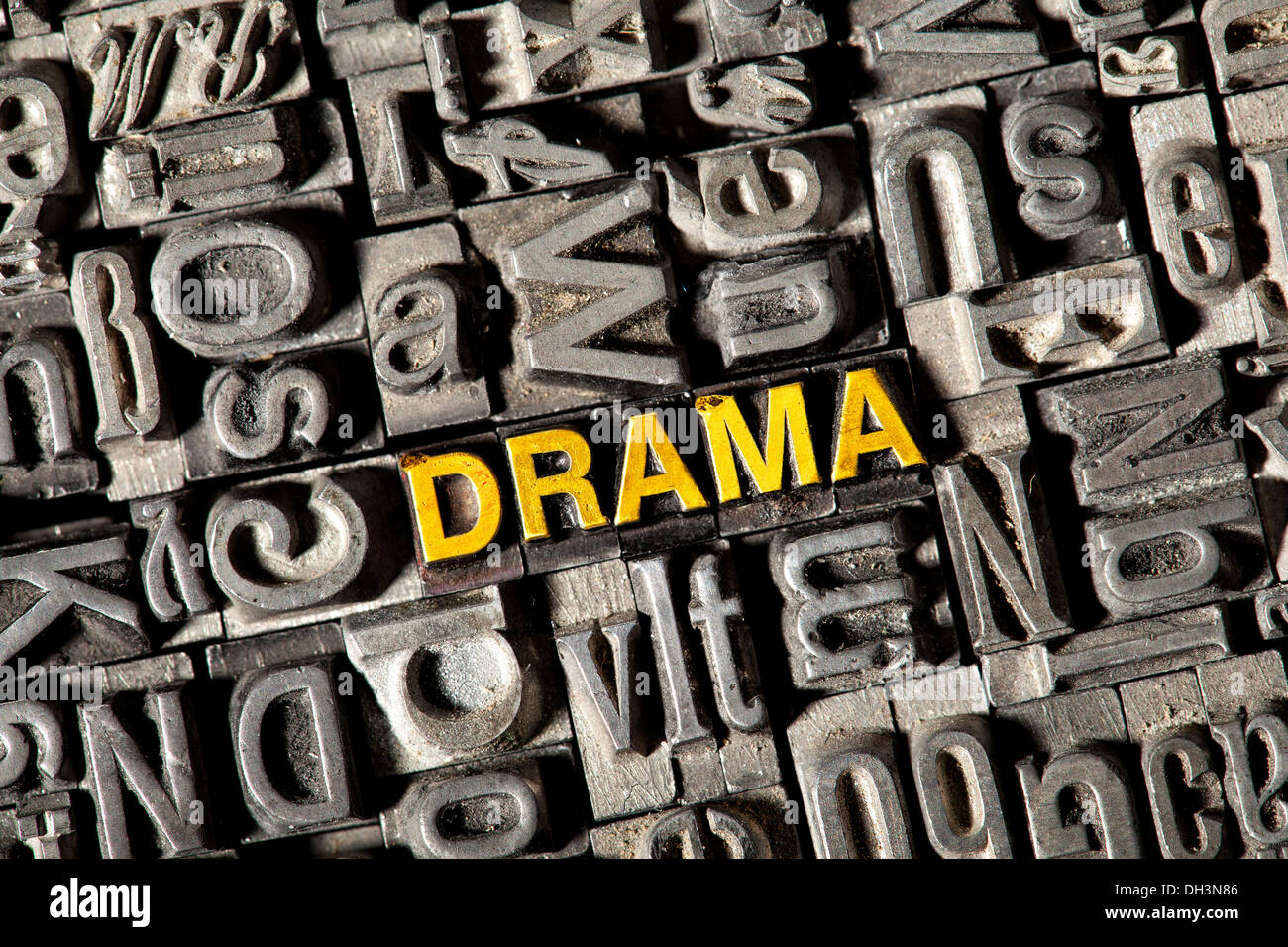 Old lead letters forming the word DRAMA Stock Photo