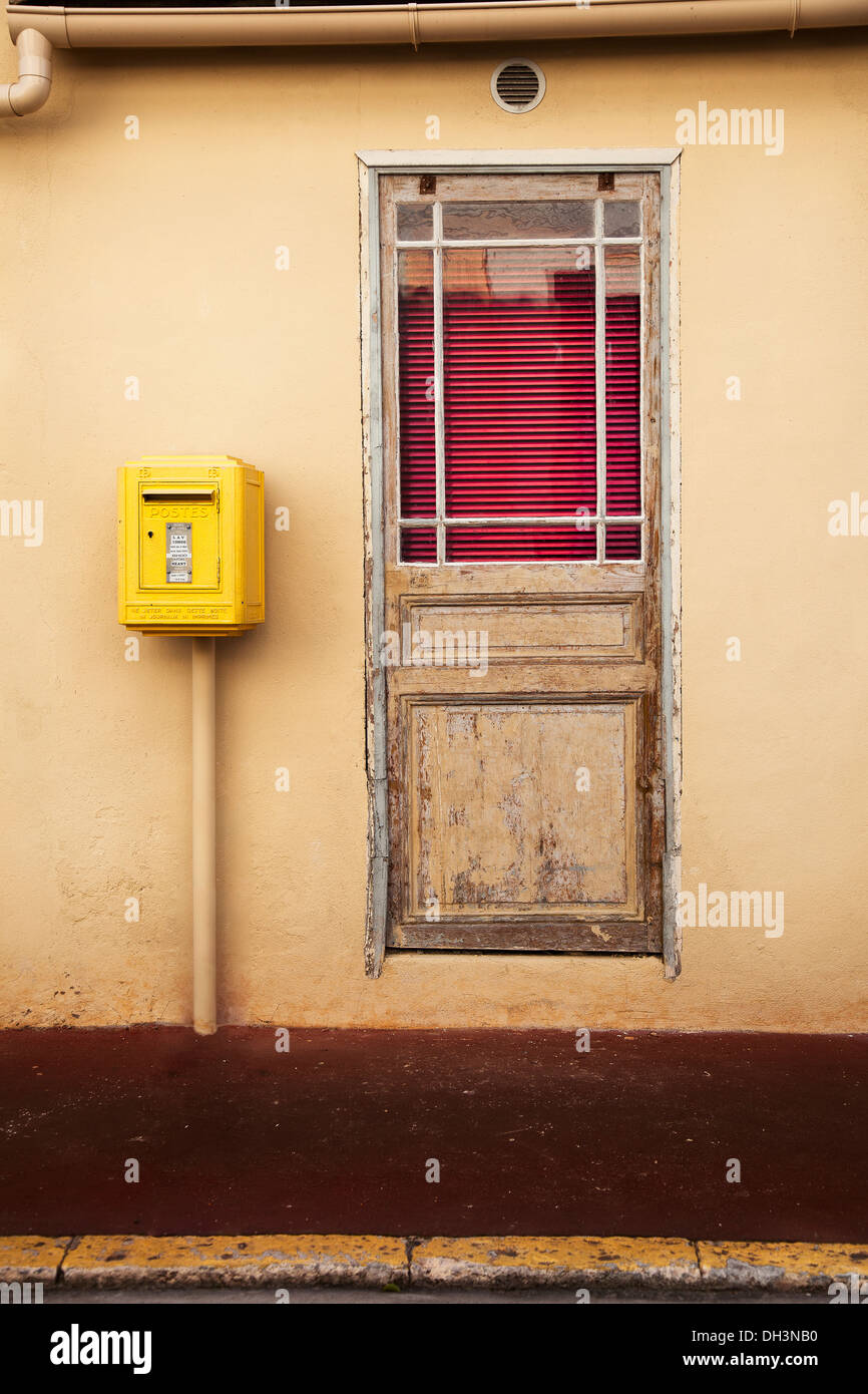 Old door with blinds and a post box next to it. Stock Photo