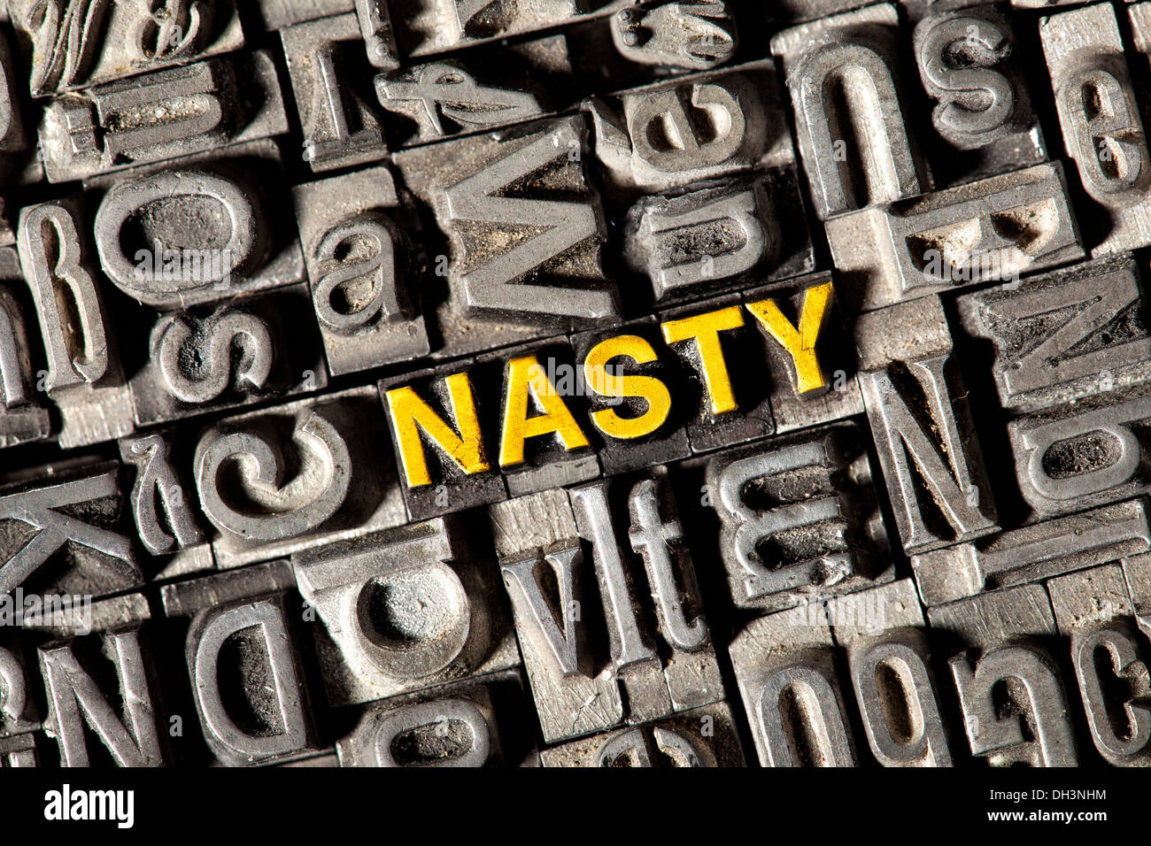 Old lead letters forming the word 'NASTY' Stock Photo