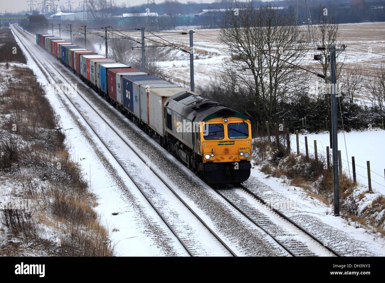 Freightliner trains 66571 Diesel Powered Freight Train, pulling containers, East Coast Main Line Railway, Cambridgeshire England Stock Photo
