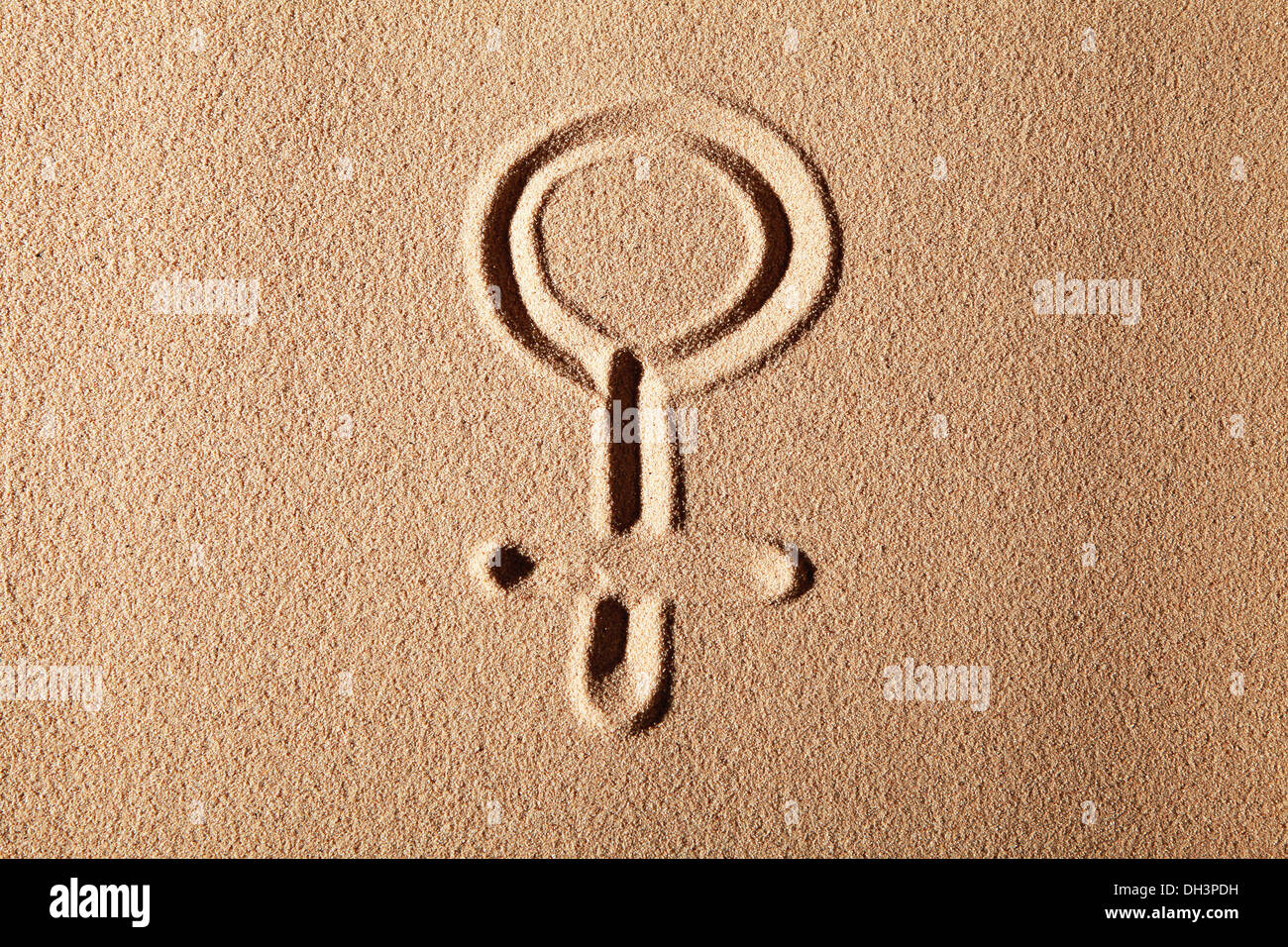 Venus sign, symbol of femininity, drawn in sand Stock Photo