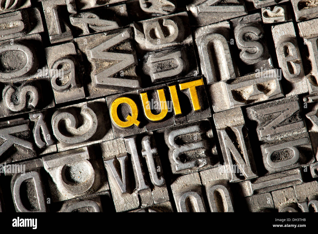 Old lead letters forming the word "QUIT" Stock Photo