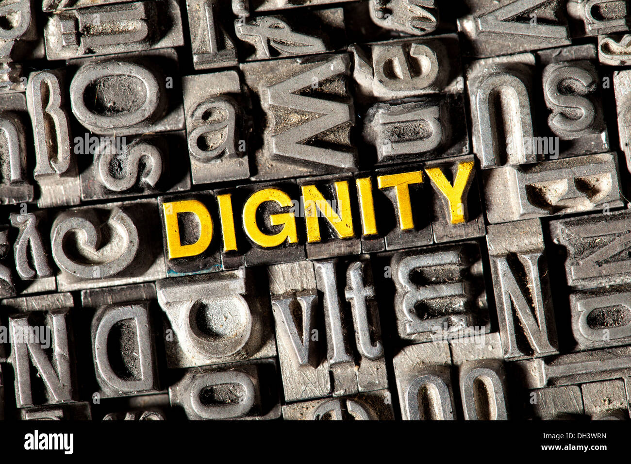 Old lead letters forming the word Dignity Stock Photo