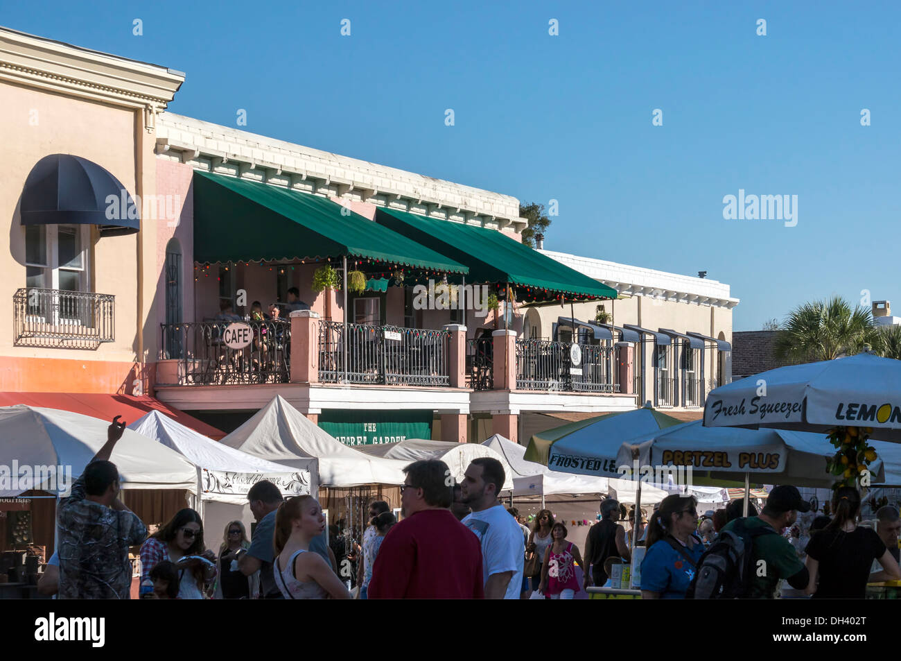 People walking around Mount Dora Craft Festival Fair and dining on a balcony cafe restaurant eatery. Stock Photo