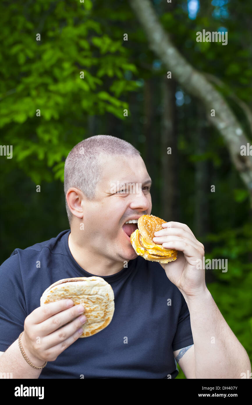 Man with burger and kebab in the hands Stock Photo