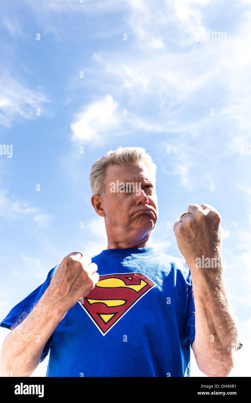 Humorous Senior Man Pretending to be Superman Stock Photo