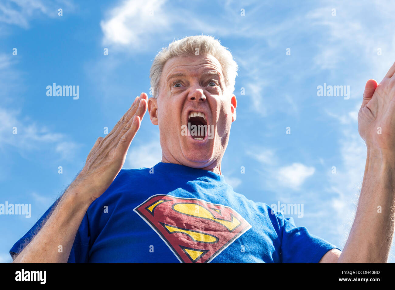 Humorous Senior Man Pretending to be Superman Stock Photo