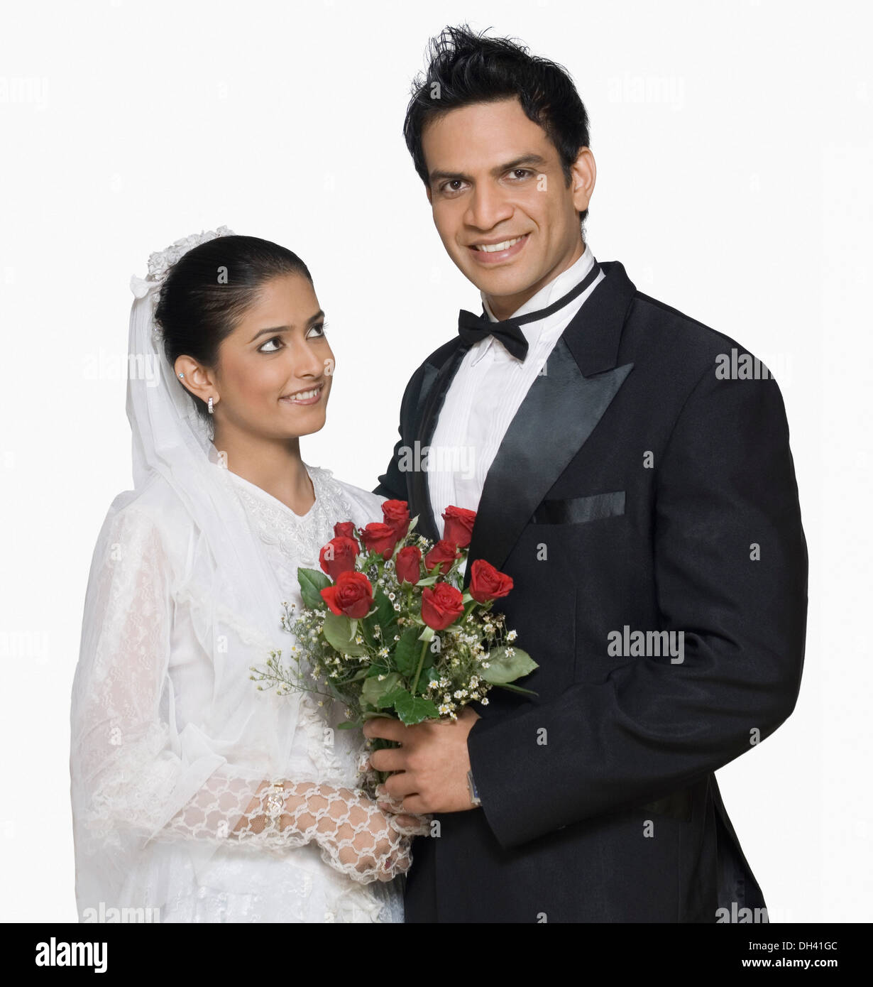 Portrait of a newlywed couple holding a bouquet of flowers and smiling Stock Photo