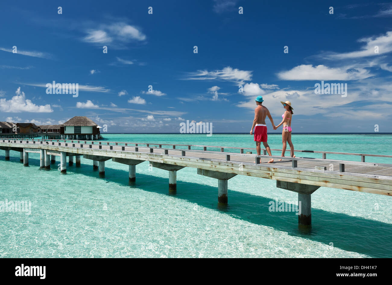 Couple on a beach jetty at Maldives Stock Photo