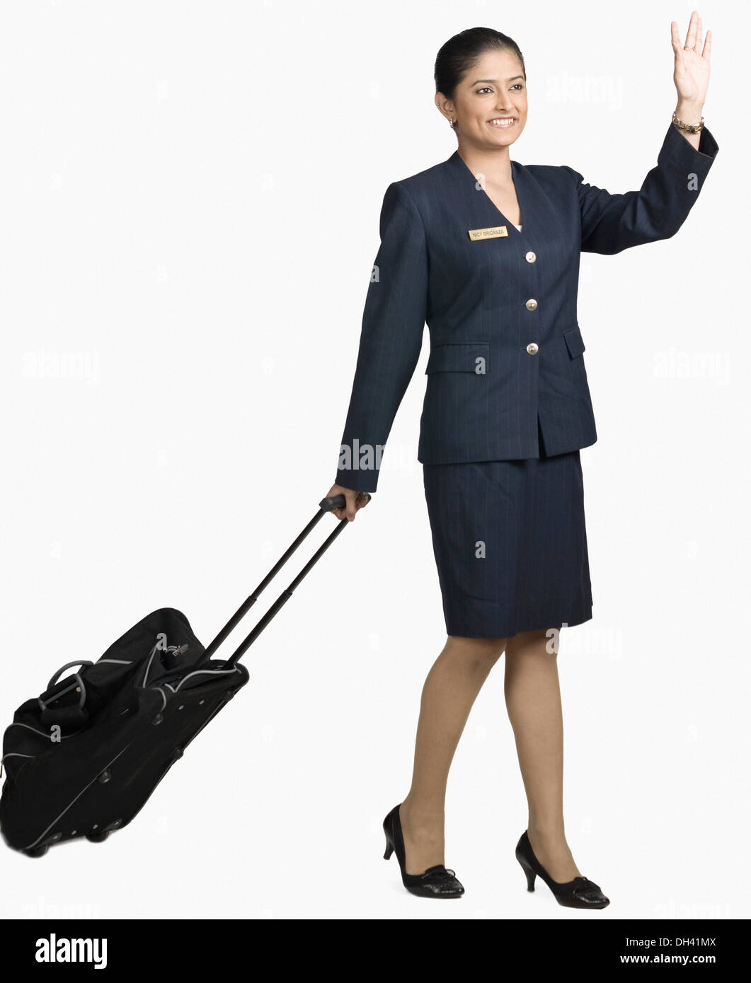 Air hostess carrying her luggage and smiling Stock Photo - Alamy