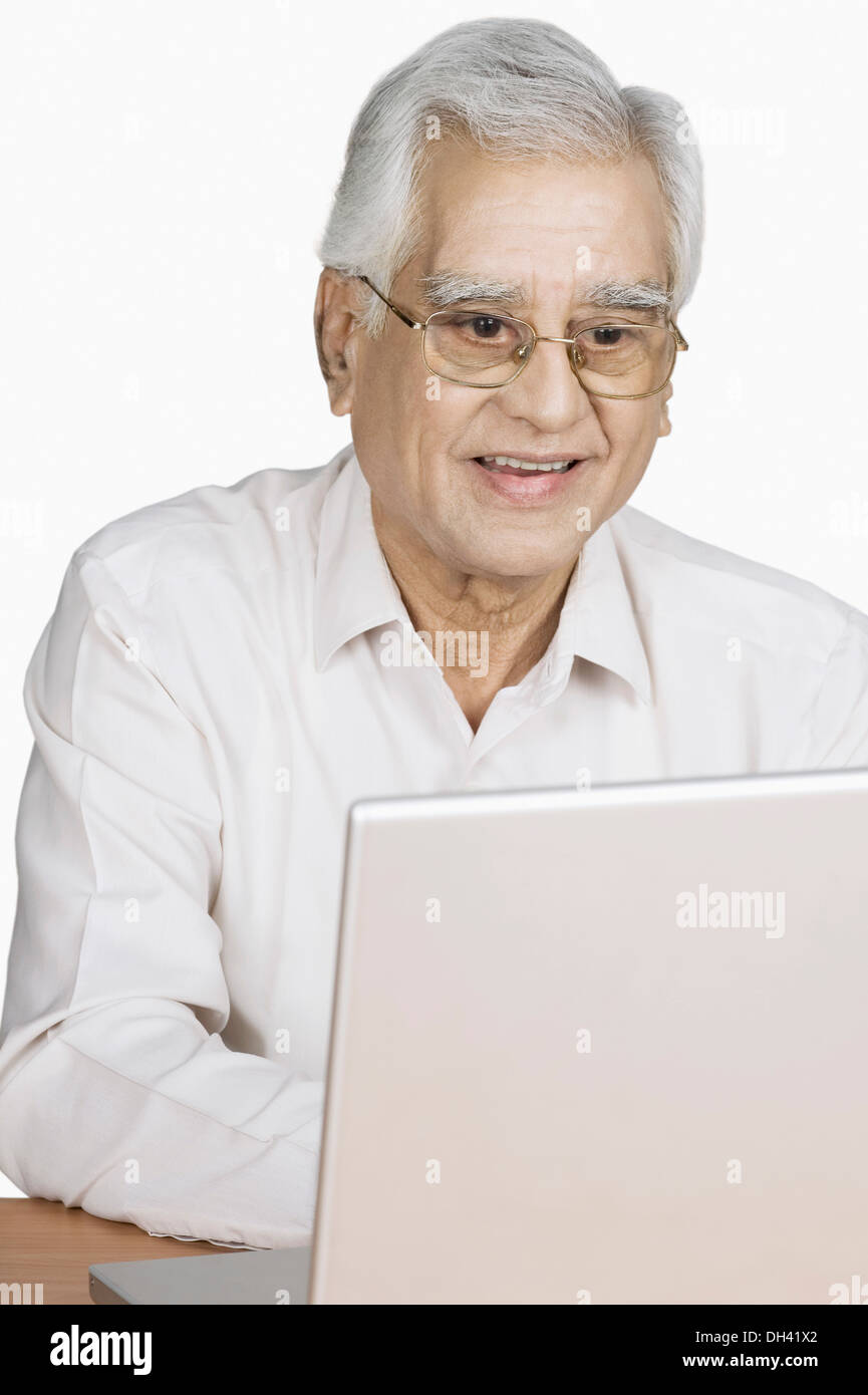 Senior man using a laptop and smiling Stock Photo