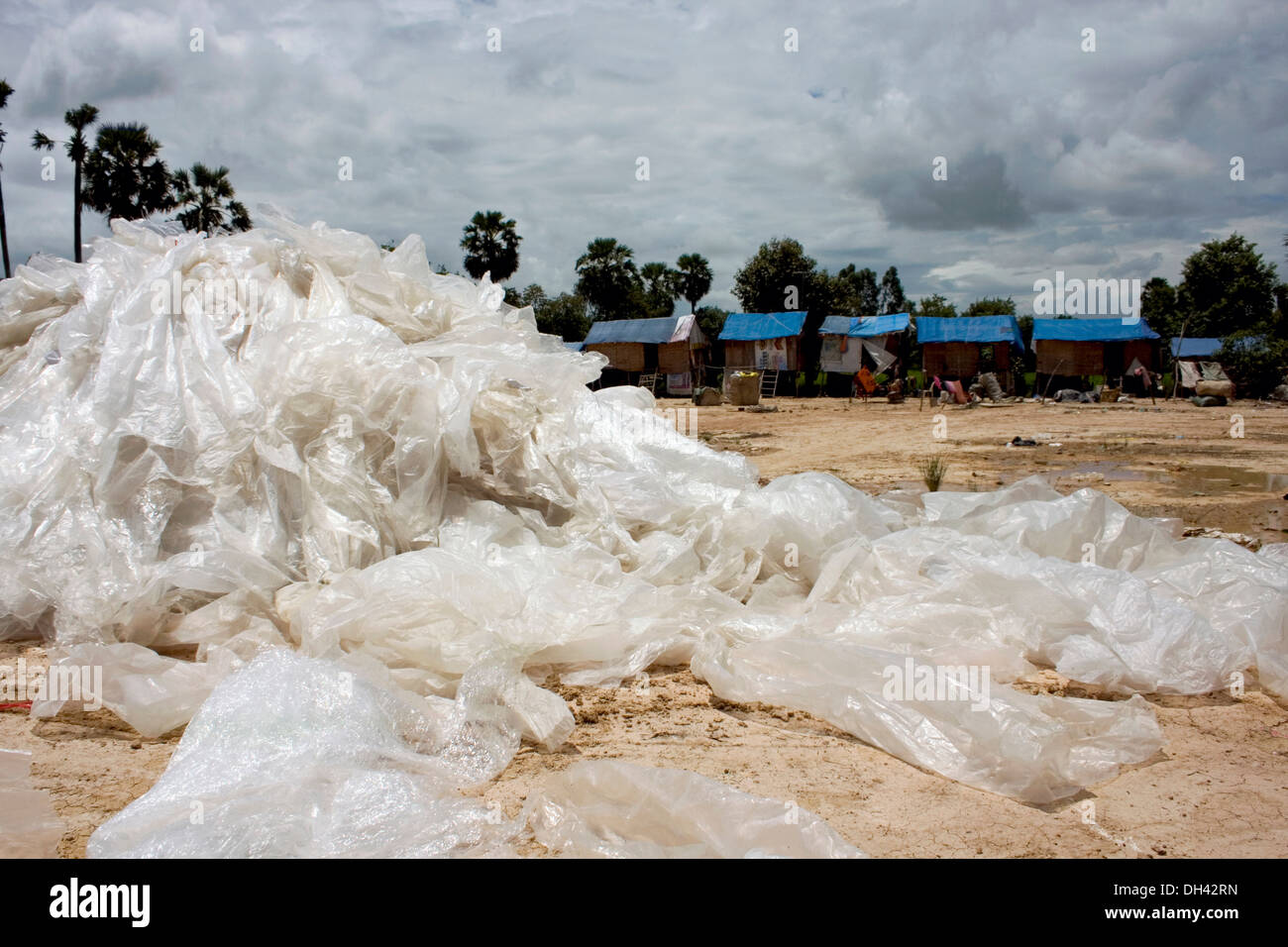 Plastic sacks are piled near homes of people who work at a recycling