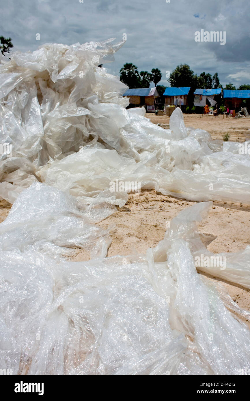 Plastic sacks are piled near homes of people who work at a recycling