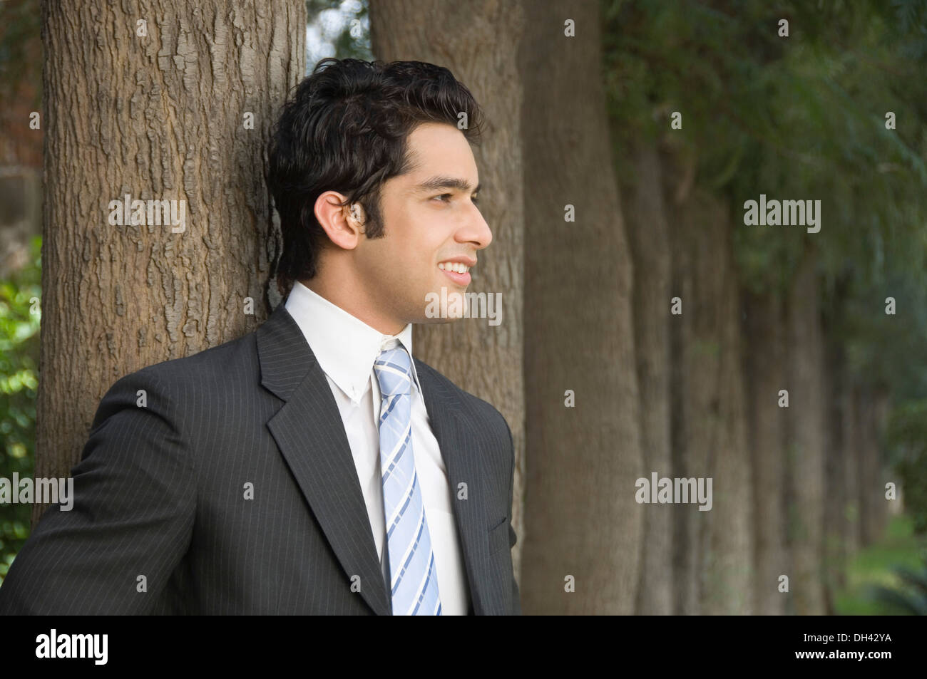 Businessman standing and smiling Stock Photo - Alamy