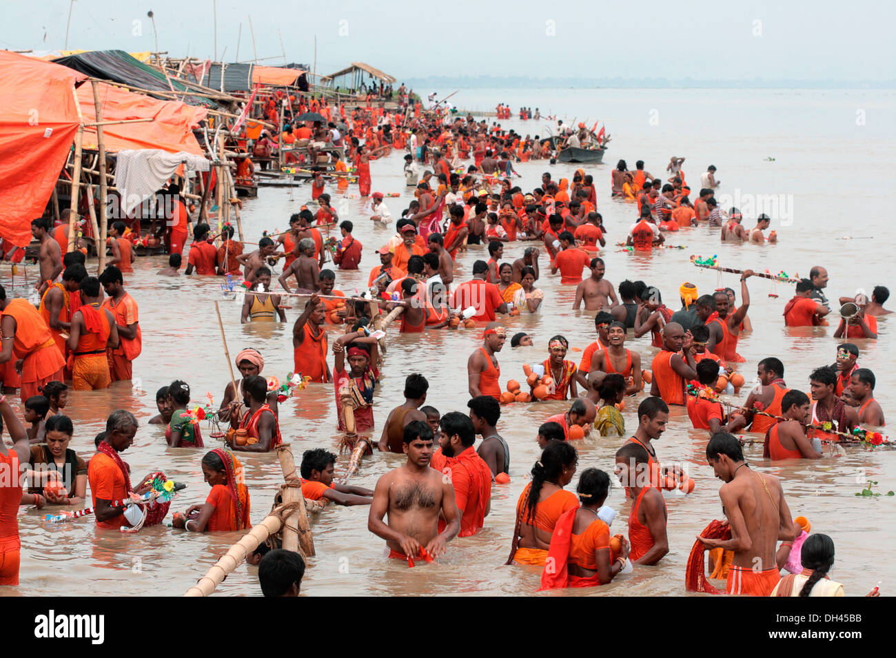 Devotees wearing saffron clothes taking holy dip bathng in Ganga river Shibratri Sultanganj Uttar Pradesh India Asia Stock Photo