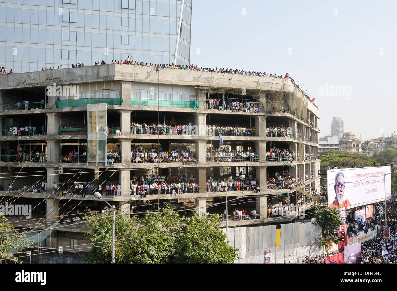 crowd of people standing in building under construction to see Balasaheb Thackeray Funeral Procession at dadar mumbai maharashtra India November 2012 Stock Photo