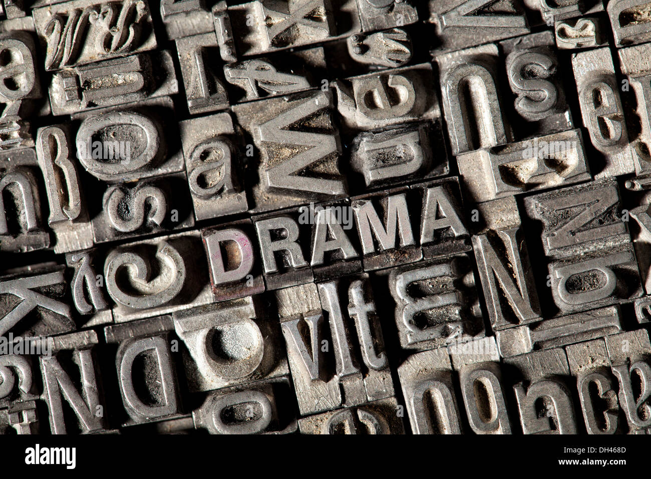 Old lead letters forming the word DRAMA Stock Photo