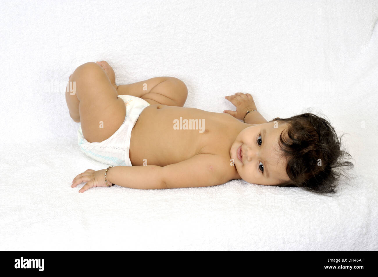 Baby in diaper lying on his back on white background   MR#736PA Stock Photo