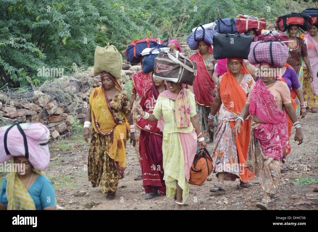 Indian women balancing luggage bags on head walking Padyatra Jodhpur Rajasthan India Asia Stock Photo