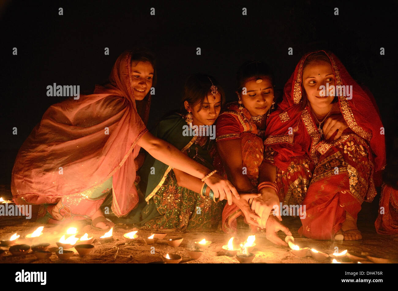 Indian women lighting oil lamps on Diwali festival of lights Jodhpur