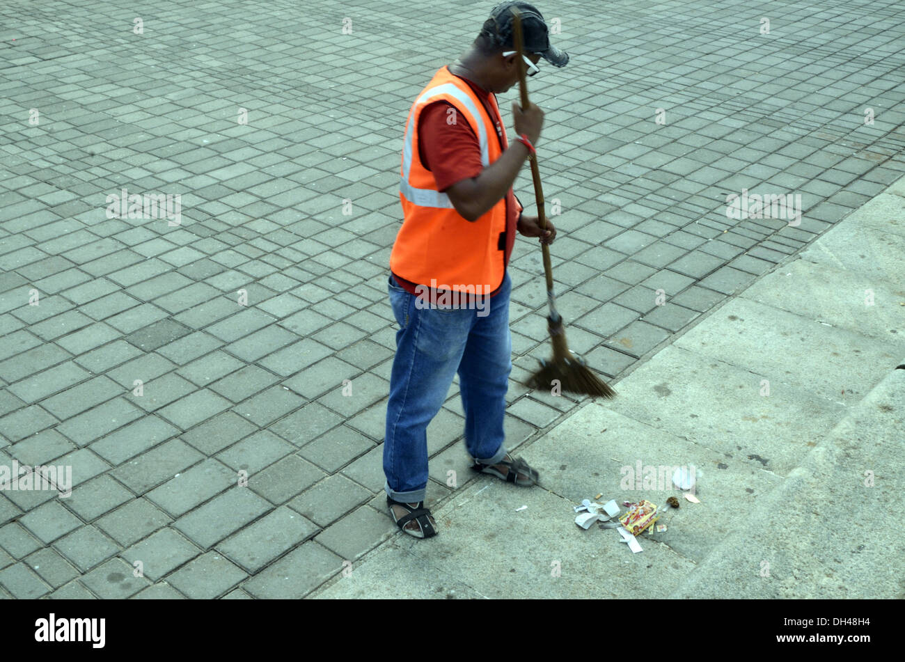 Man sweeping cleaning footpath Marine Drive Mumbai Maharashtra India